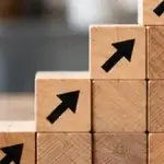 Editorial image showing wooden ascending-arrow business-growth concept.